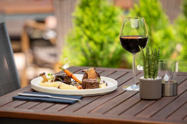 Terrasse mit Tisch, Gericht und Rotwein